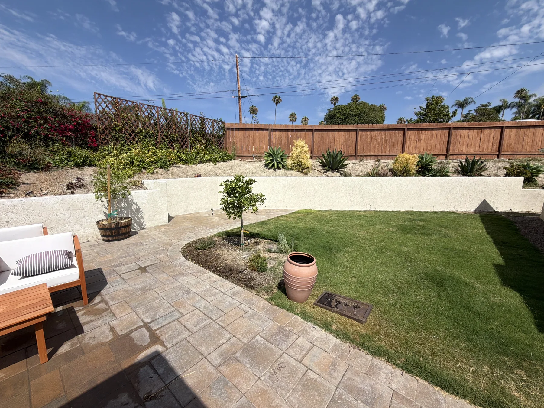 Smooth white stucco garden wall and finished patio in a San Diego County backyard