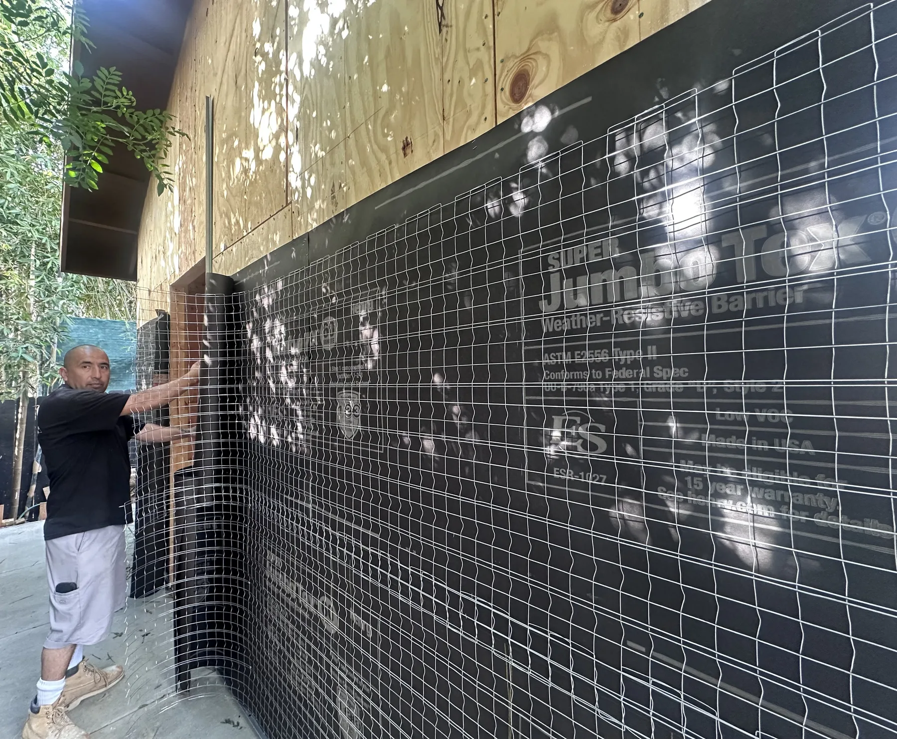 Galvanized wire lath going on over the weather-resistive barrier before stucco