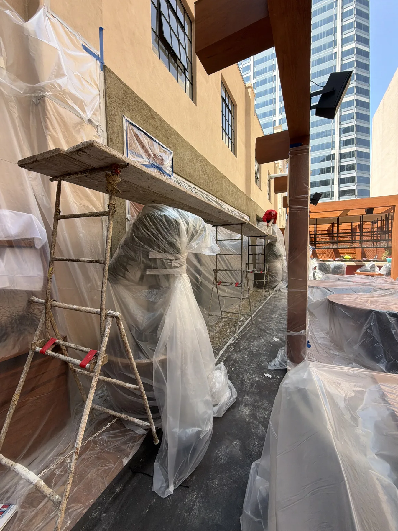 Masked and protected commercial plaster work on a downtown San Diego courtyard