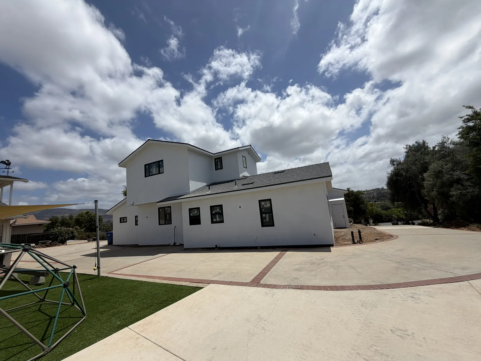 Completed smooth white stucco on a two-storey new construction home in Bonita by Maya Stucco Inc.