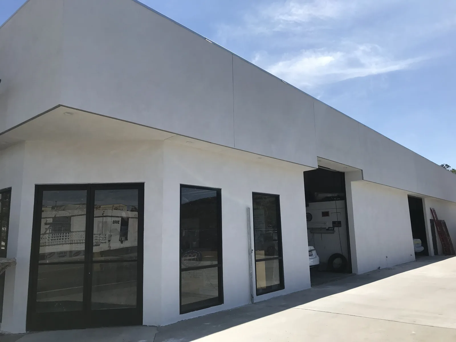 Refinished smooth white plaster on the street frontage of an Oceanside commercial building by Maya Stucco Inc.