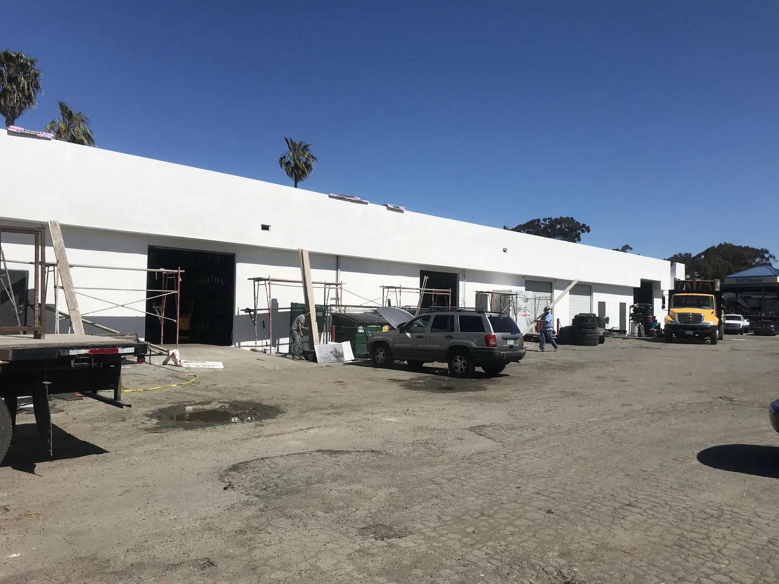 Finished white stucco along the full service bay elevation of an Oceanside commercial building