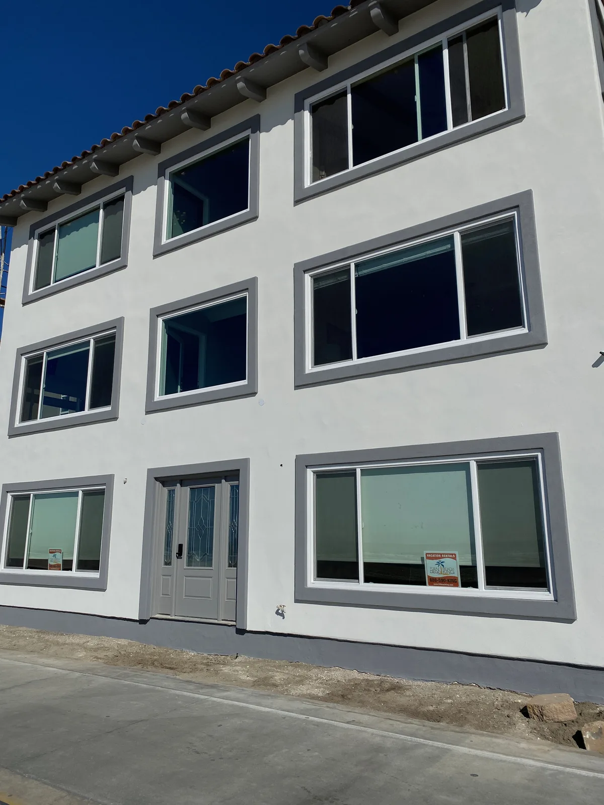 Detail of finished white stucco and grey window surrounds after refinishing in Pacific Beach